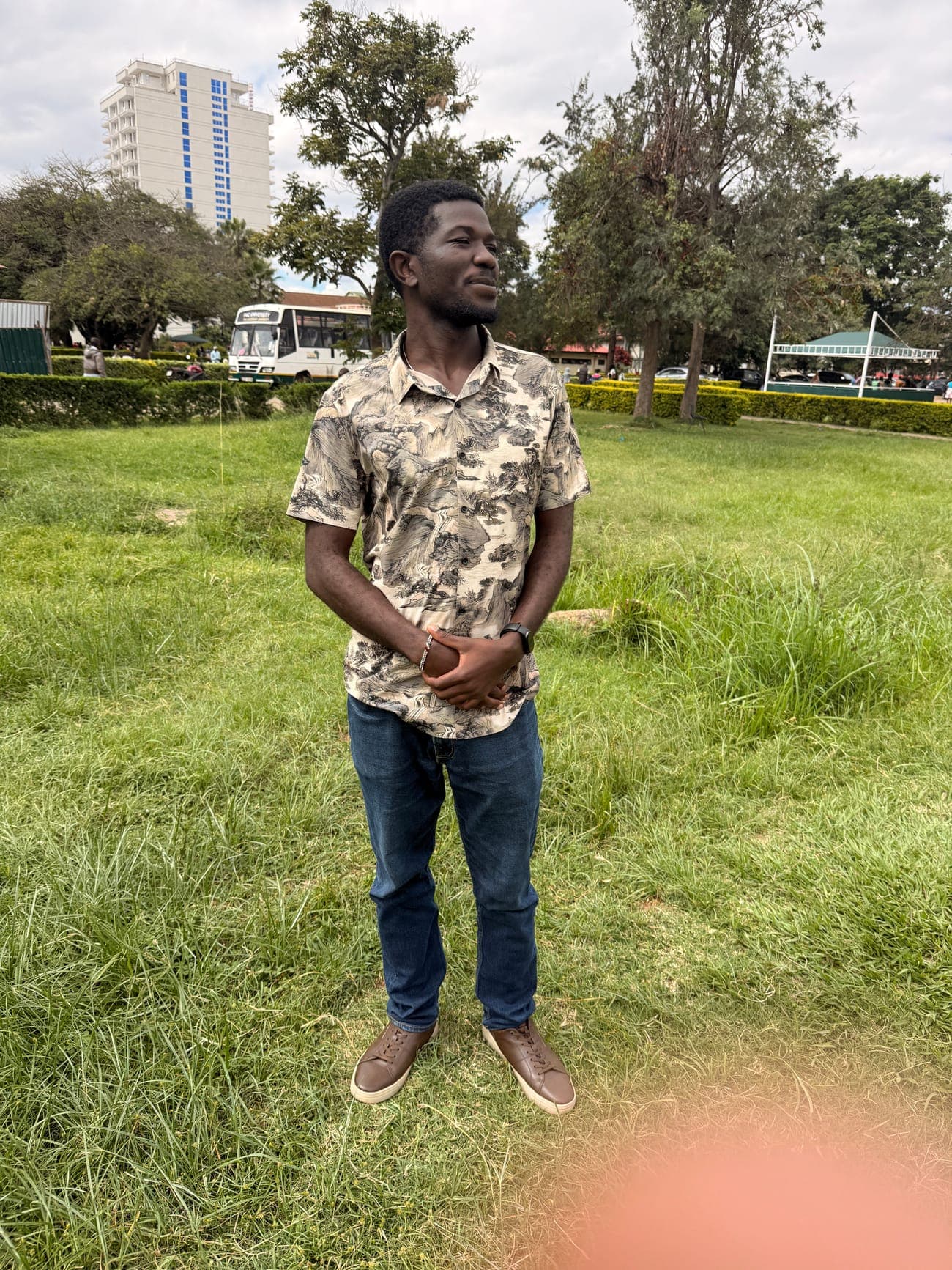 Mashel standing on green church grounds with the city behind